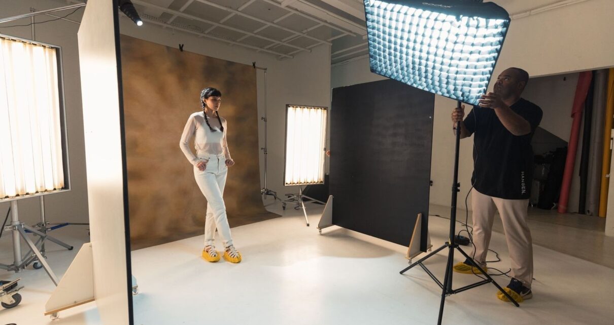 Modell och fotograf förbereder en porträttfotografering i studio